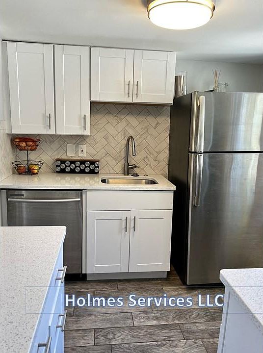 Designer herringbone backsplash. Appliances include a dishwasher and garbage disposal.