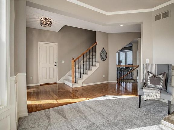 Spacious foyer with new lighting and hardwood floors. Iron spindles with upgraded NEW stair carpet.