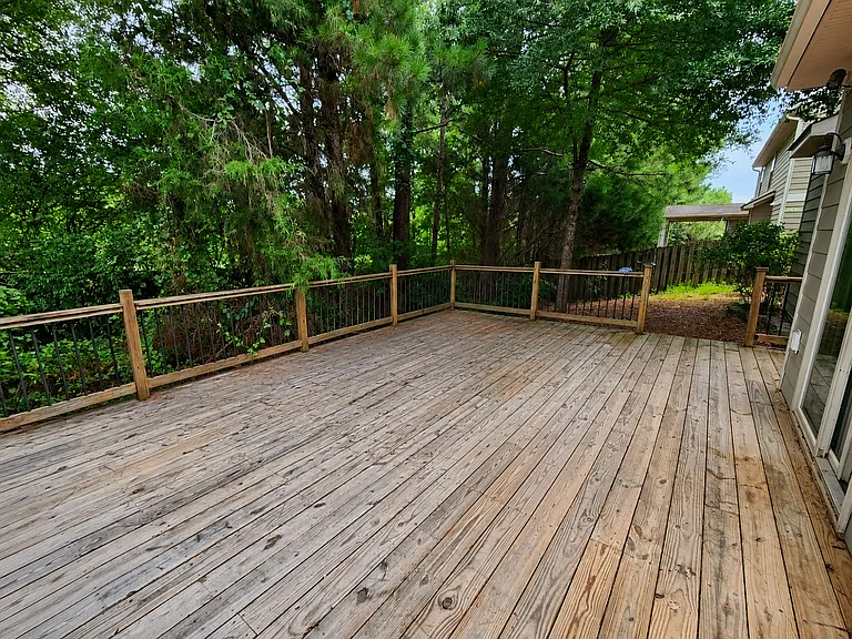 Deck on the back with trees.