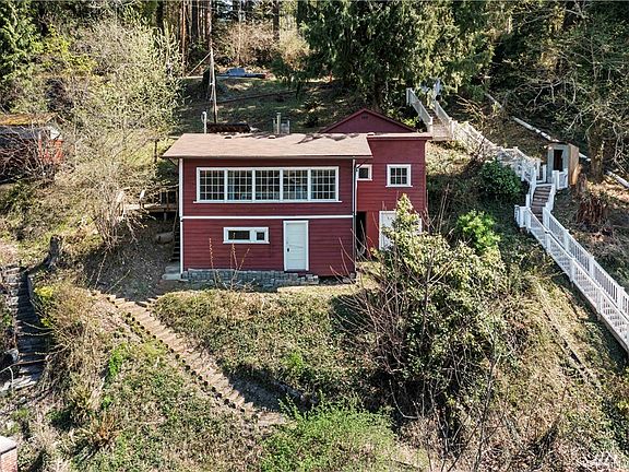 Elevated aerial drone shot looking at cabin from the lake.