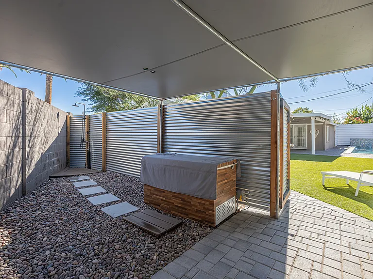 Covered ice bath are with adjacent outdoor shower for year-round wellness use