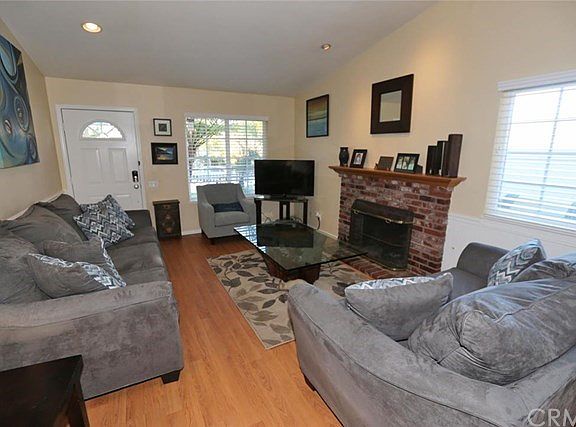 Wood laminate floors, cathedral ceiling and fireplace make an inviting living room.