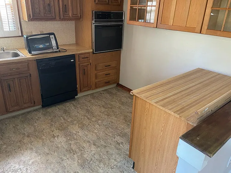 Kitchen includes fridge, table top stove, dishwasher, oven, and garbage disposal. Moveable counter. Plenty of cabinet space.