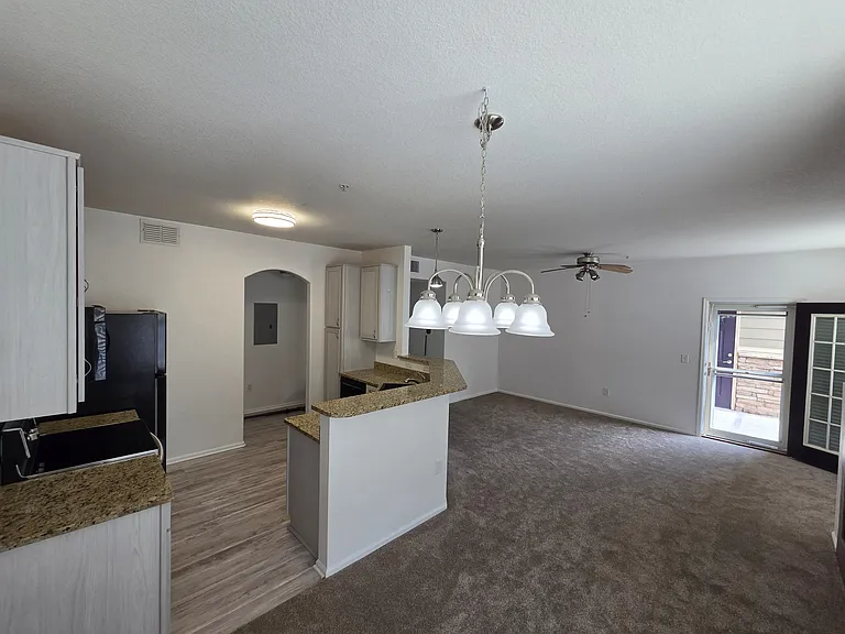Looking back at the living room, kitchen and balcony door from the dinning area