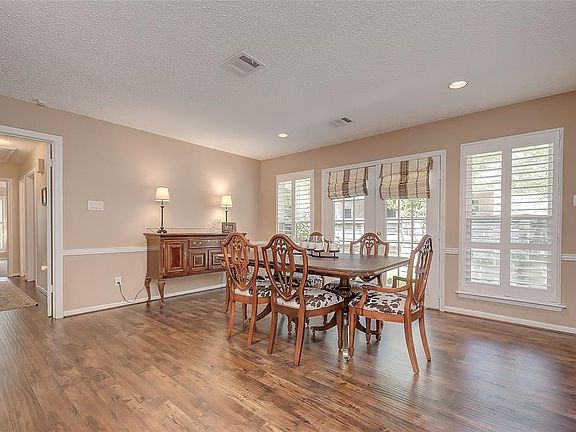 The dining room has high end laminate wood floors, recessed lighting and plantation shutters.