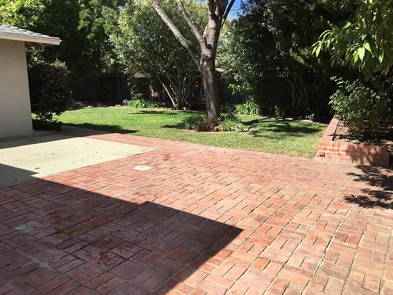 Large brick patio in backyard.
