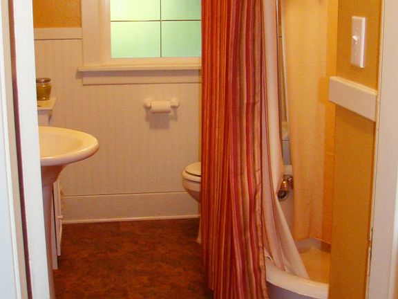 remodeled bathroom with clawfoot tub and wainscotting