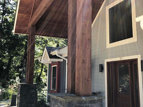 ELEGANT CEDAR FRONT PORCH ROOF AND COLUMNS ALONG WITH A CUSTOM MOGANY FRONT DOOR MAKE FOR A GRAND ENTRANCE
