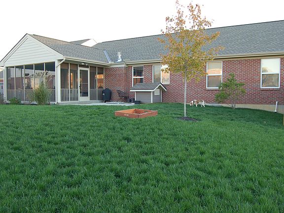 Back of home with screened porch and patio