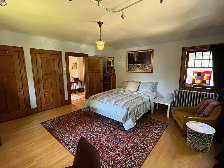 Massive middle bedroom with brand new Queen bed, chair, dresser, desk, two closets, and book shelf