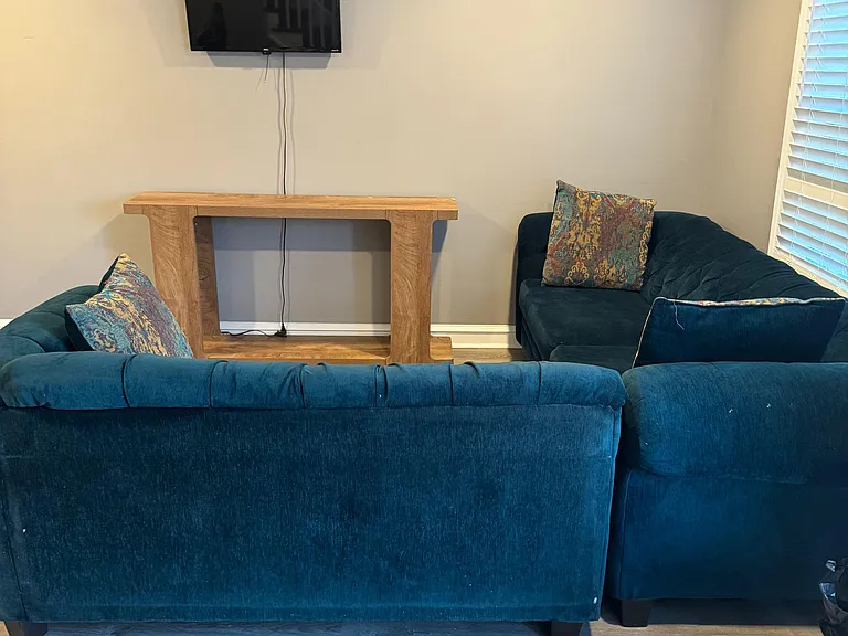Shared living area with comfortable seating, wall-mounted TV, and durable flooringideal for relaxing or streaming.