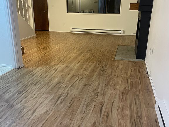 View from dining room into living room and front entrance. Since this is an end unit, the main floor window has a private feel to it, not open to any foot traffic.