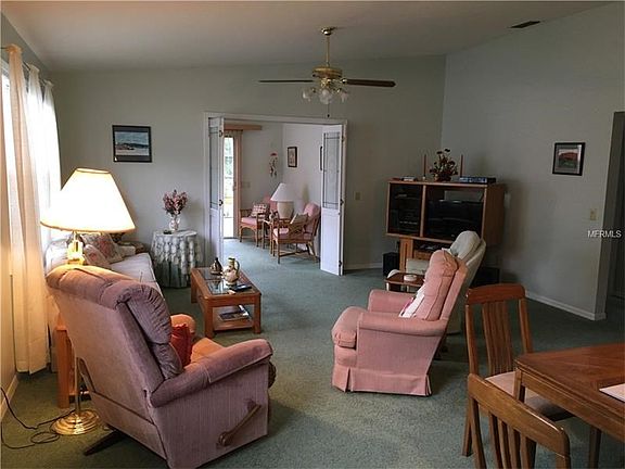 View of Living room & Florida room with French doors showing ceiling lights & fan.
