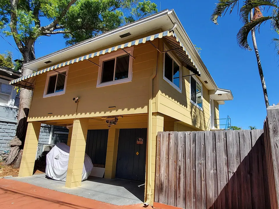 Includes parking space on left side of the garage. This shows upstairs porch/office upstairs. Gate entry to the left of the fence.