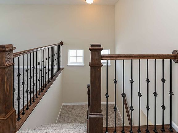 Oak railing with metal spindles creates an open feeling in the stairwell.