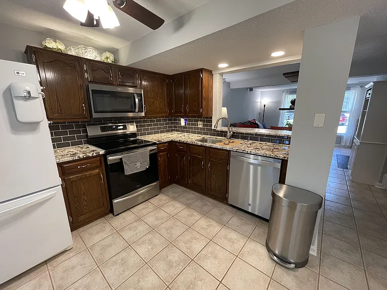 Kitchen with ceiling fan, high-end appliances including an induction stove with convection oven, undercabinet lighting with no-touch switch, over sink recessed lighting