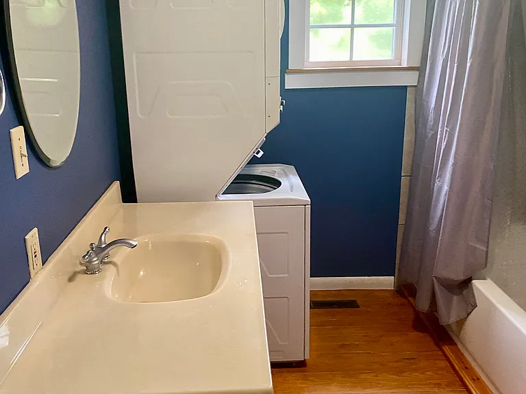 Full bathroom, stacked washer/dryer and tiled bath/shower.