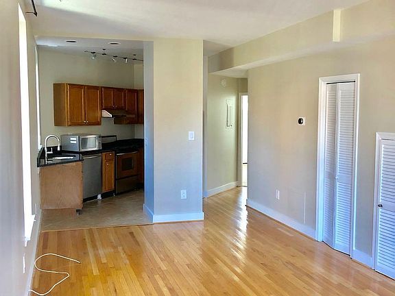 Front of the apartment looking toward the kitchen (left) and hallway (right)