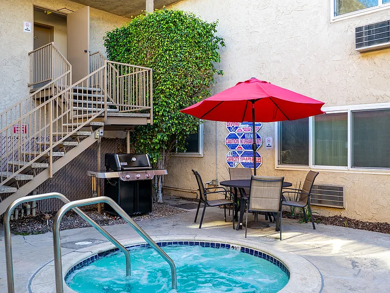 The relaxation area at Esplanade features a heated spa, a bbq grill, and outdoor seating for residents to enjoy.