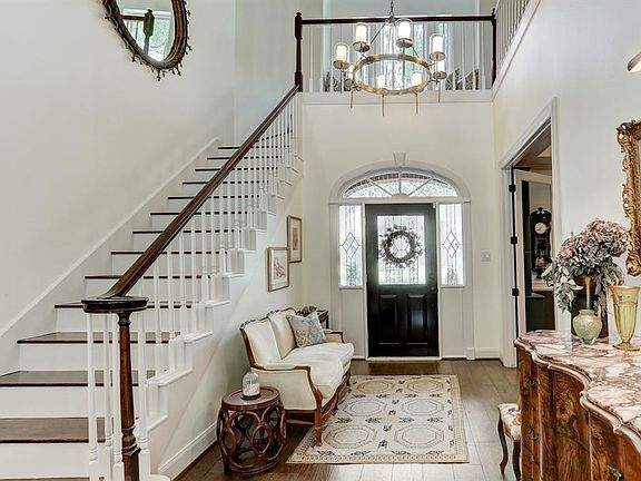The light and bright entry boasts gleaming hardwoods and a beautiful wood stairway that leads to the second floor. Fresh paint has been added around the front door since this photo was taken.