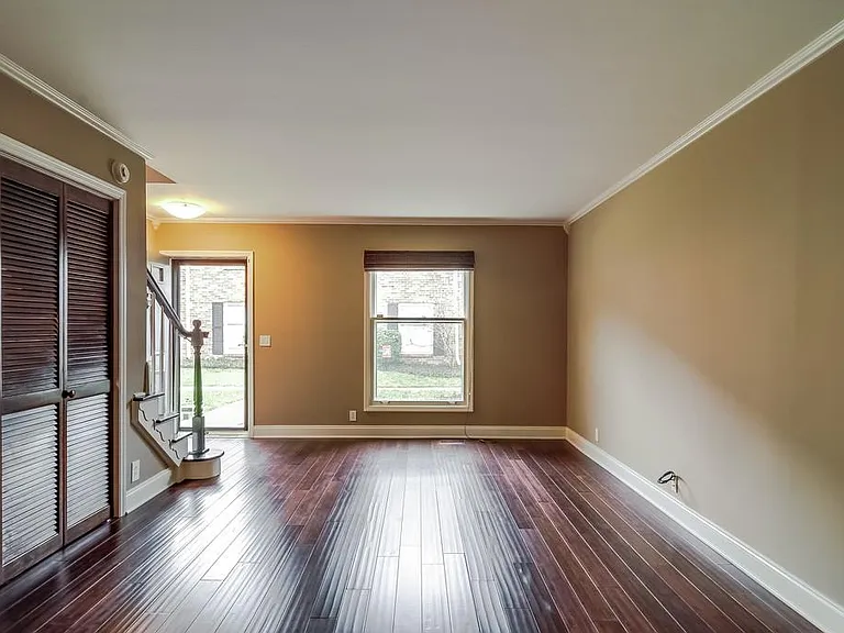 living area with washer and dryer behind louvered doors on left