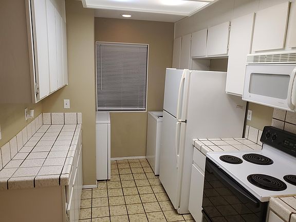 Kitchen with washer, dryer, electric range, fridge, microwave & dish washer.