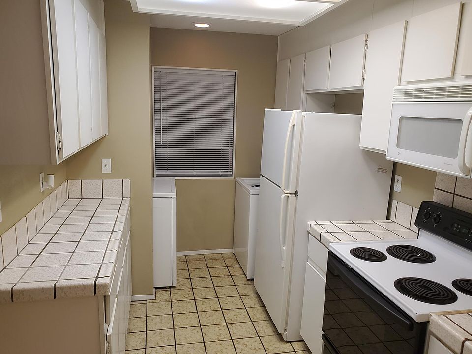 Kitchen with washer, dryer, electric range, fridge, microwave & dish washer.