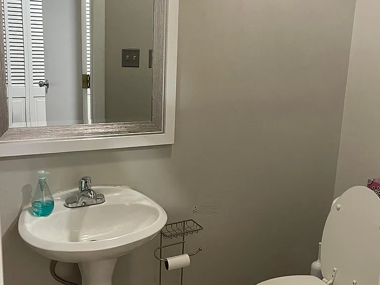 Powder room off kitchen and down hallway