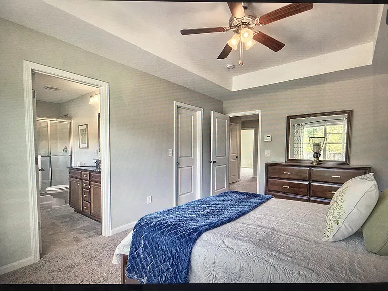 Master bedroom staged with view of master bath.