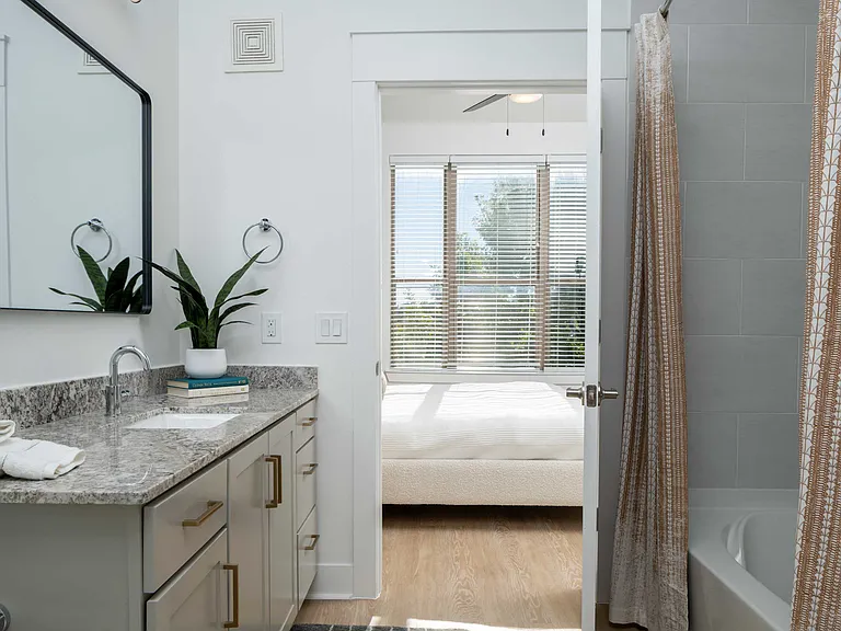 Upscale baths with framed mirrors and large format tile flooring