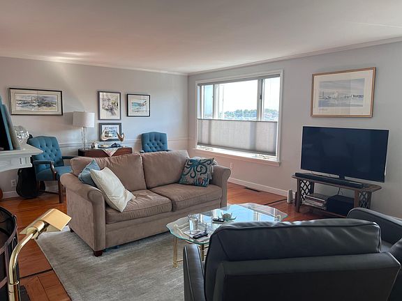 Living room with 2 large windows overlooking harbor,