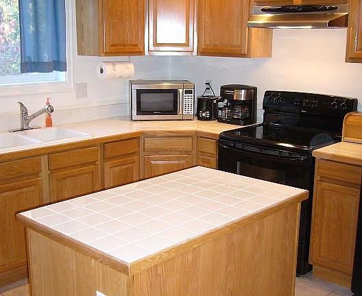 Open kitchen with tile and oak cabinets