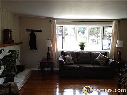 Main floor LR with hardwood, bow window, and fireplace