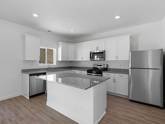The kitchen has white wood cabinetry.