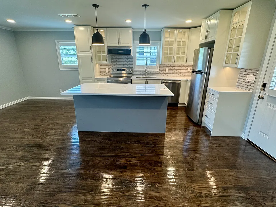 View of the kitchen with gorgeous hand-scraped hard wood floors and terrific lighting. The front door is to the right and the bathroom and walk-in closet are behind.