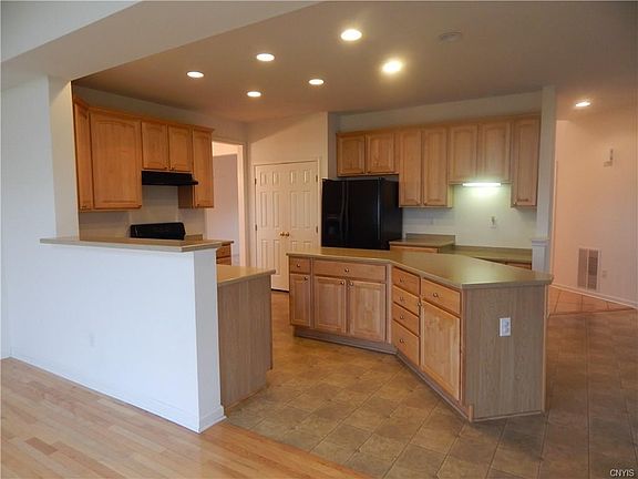 Kitchen with center island and maple cabinetry includes large pantry
