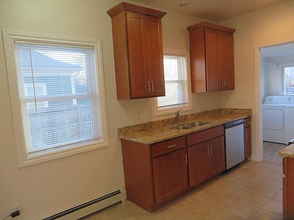 Tall cabinets with plenty of storage, granite countertops, stainless steel sink and dishwasher.