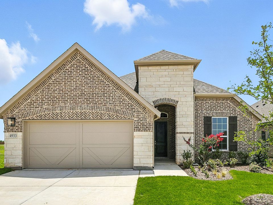 Luxurious brick facade with elegant arched entry and manicured landscape in Hulen Trails, Texas.