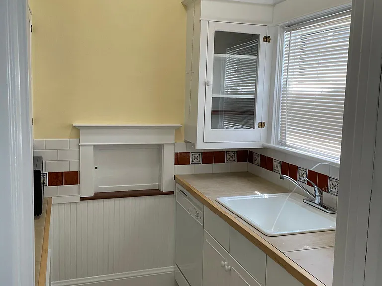 Kitchen has this butler's pantry with sink and storage and a separate area with the stove, refrigerator, sitting area and access to the back yard and basement.