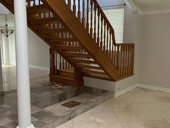 Large staircase at entrance with step down formal living room