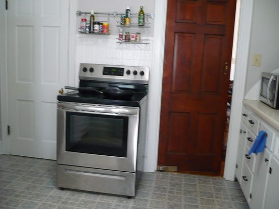 stove and swinging door to dining room on right.Door to left is basement door
