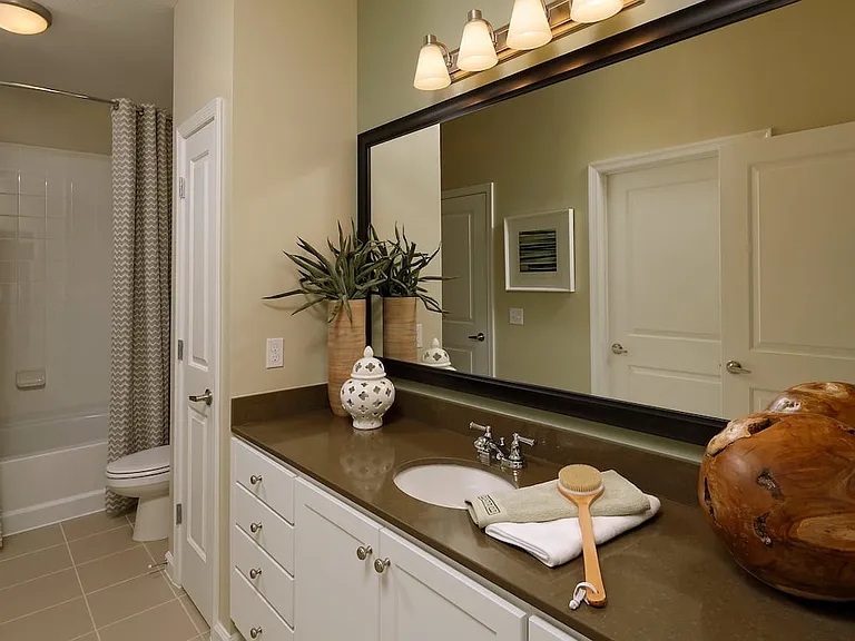 Bathroom with quartz stone countertop, white cabinetry and linen closet