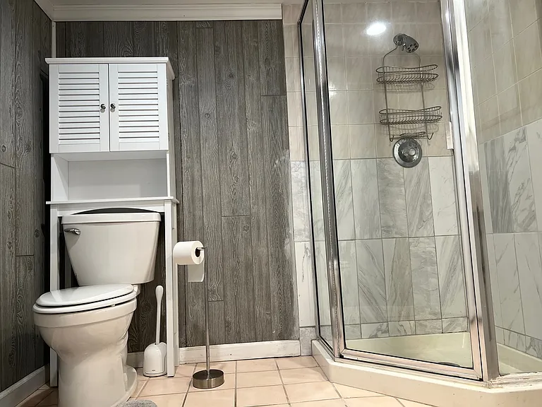 Clean roomy full bathroom located in the bedroom area.