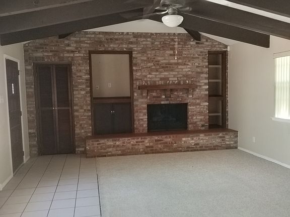 Living area with fireplace and exposed beams.