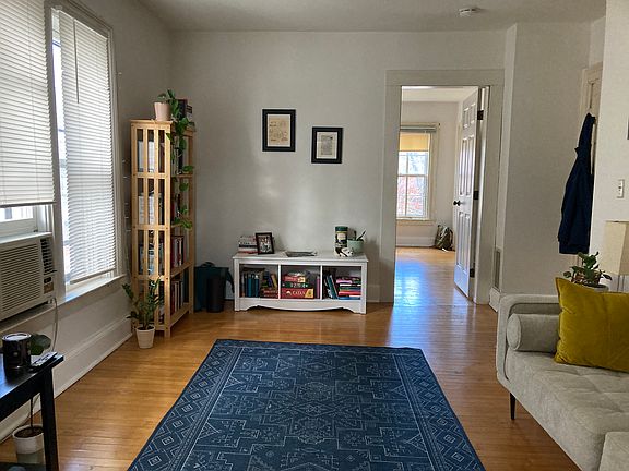 Bright Living Room with High Ceilings. Door Leads Into Bedroom.