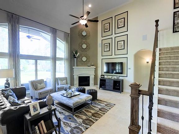 The spacious Great Room features a corner fireplace, a two-story ceiling and a stunning wall of wind