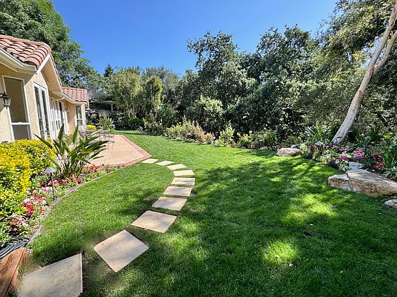 Backyard patio and rose garden with path to game court area.