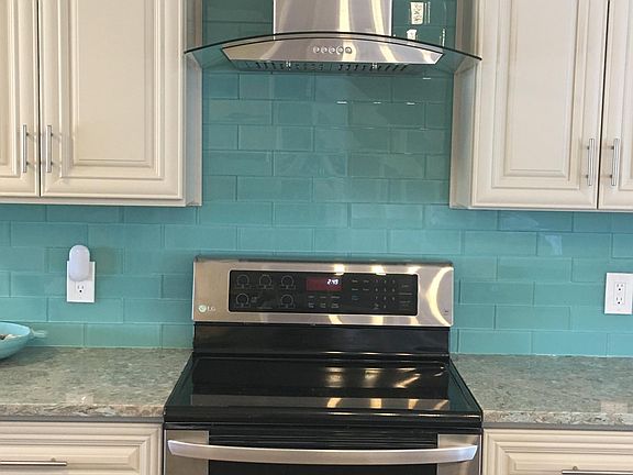 Stainless steel stove with glass/stainless hood.
