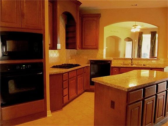Large island granite kitchen with barely used appliances.