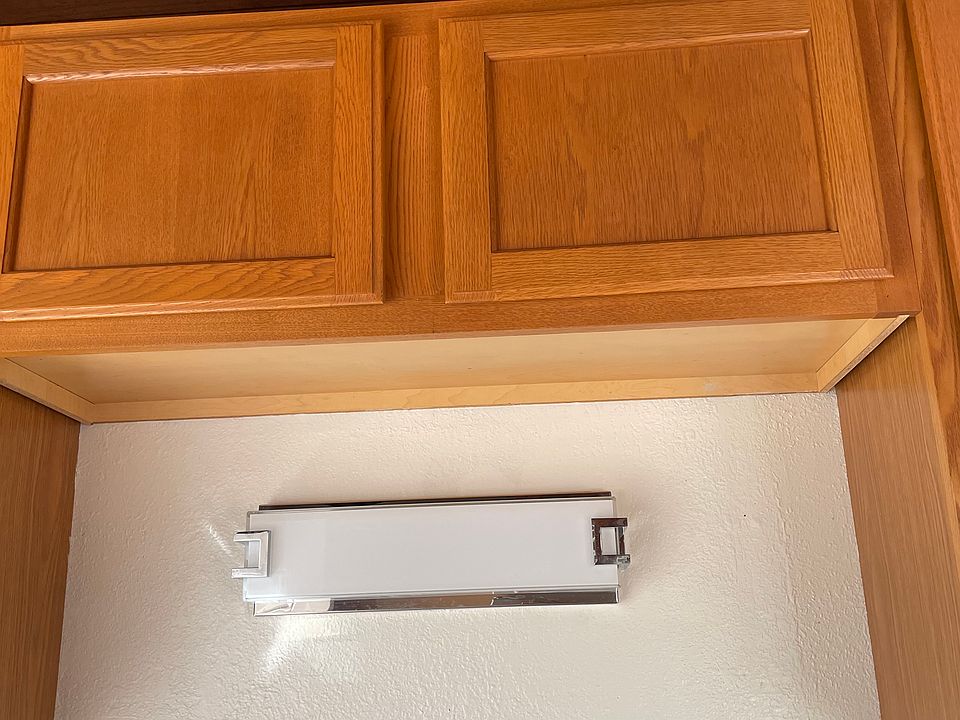 Kitchen cabinets over stainless double sink with light